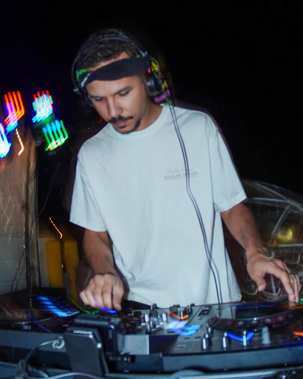 SlowJamSteve wearing headphones and mixing behind the decks